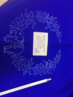 a blue table cloth with writing on it and a pencil in front of the label