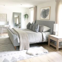 a large bed sitting in the middle of a living room next to a white table