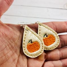 a pair of earrings with an orange design on them