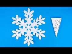 an origami snowflake is cut out and placed on a blue background