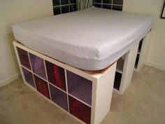 a bed with a mattress on top of it and several drawers in front of it