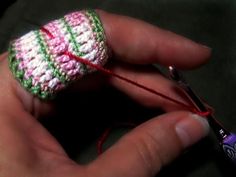 a hand holding a pair of crocheted scissors