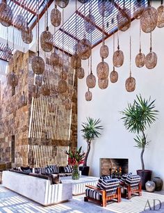 a living room filled with lots of furniture next to a fire place and potted plants