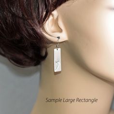 a mannequin head with a pair of earrings hanging from it's ear