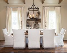 a dining room table with four chairs and a chandelier hanging from the ceiling