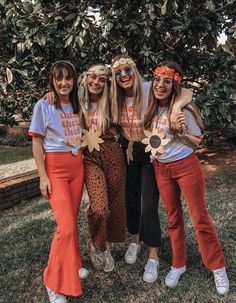 three girls in matching outfits posing for the camera with one girl wearing an orange outfit