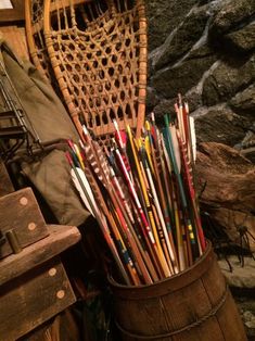 a basket filled with lots of different colored arrows next to a pile of other items