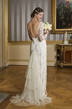 a woman in a wedding dress looking down at her bouquet