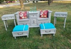 an assortment of furniture in the grass with blue and red pillows on top of them