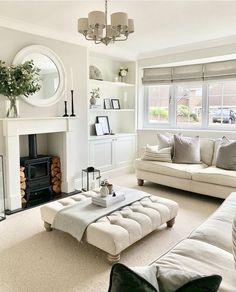 a living room filled with furniture and a fire place in front of a mirror on the wall