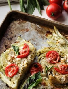 an uncooked pizza sitting on top of a pan covered in cheese and tomatoes