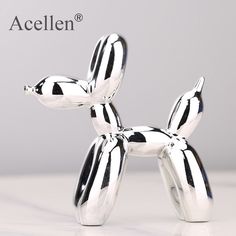 a silver balloon dog sitting on top of a white table