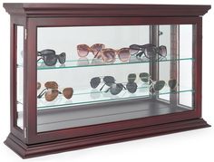 a display case filled with lots of different types of sunglasses on top of glass shelves