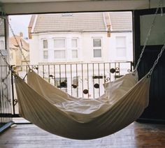 a white hammock hanging from a balcony