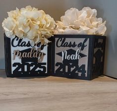 two black and white boxes with flowers in them