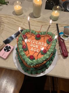 a cake with candles on it sitting on top of a table next to other items