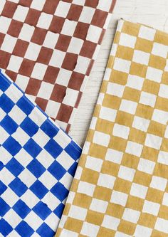 four different colored checkered cloths on a white table