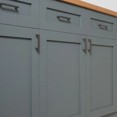 a kitchen with gray cabinets and wooden counter tops