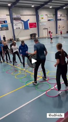 a group of people standing on top of a basketball court with hula hoops