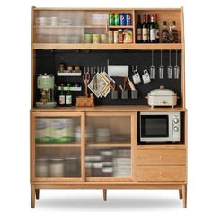 a wooden cabinet with glass doors and shelves filled with bottles, utensils and other kitchen items