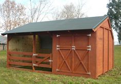 a horse barn with the doors open and hay in it's stall on grass