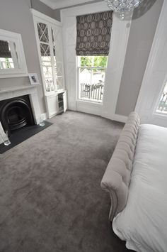 a bedroom with a bed, fireplace and two windows