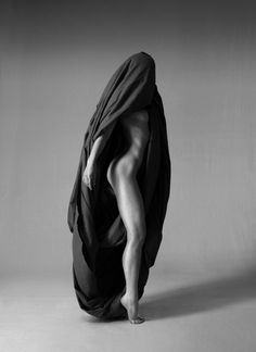 a nude woman wrapped in black cloth posing for the camera with her legs spread out