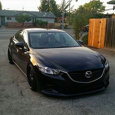 a black car is parked on the street