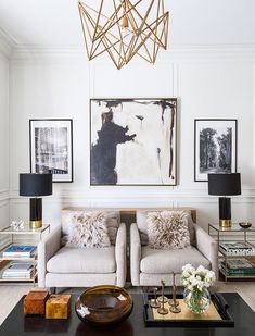 a living room with two couches and a coffee table in front of a painting on the wall