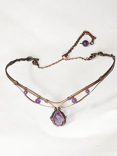 Enhance your look with this stunning 6ct Amethyst choker in copper! Handcrafted with quality materials, this choker features a beautiful Amethyst gemstone in the center, set in copper wire wrap that creates a beautiful and eye-catching design. The copper wire wrap is intricately detailed and flows gracefully around the gemstone, giving it an elegant feel. The choker fits comfortably around the neck and is lightweight enough to be worn all day. You'll be sure to make a bold statement with this un Wire Necklace Patterns, Luxury Wire Wrapped Jewelry Gift, Wire Wrap Bracelet With Stones, Wire Necklace Designs, Wire Wrapped Clasps, Copper Wire Necklace, Fantasy Wire Jewelry, Wire Choker Necklace Diy, Wire Wrap Choker