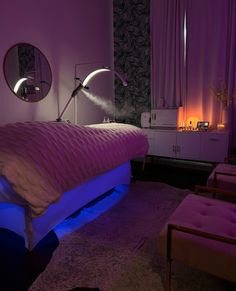 a bed in a room with purple lighting