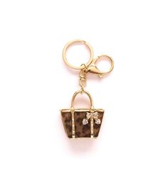 a gold keychain with a brown purse on it