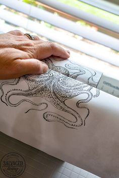 a person is drawing an octopus on a piece of paper