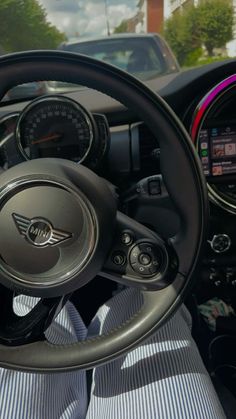 the interior of a car with steering wheel, dashboard and gauges on both sides