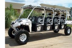 a white four passenger golf cart parked in front of a building