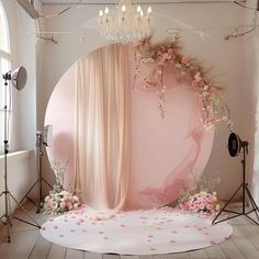 a pink backdrop with flowers and chandelier