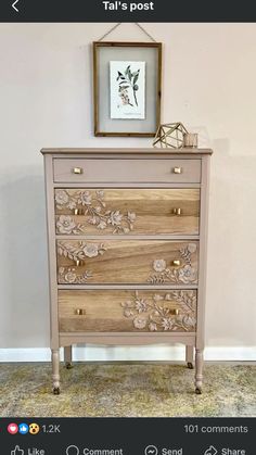 an old dresser has been decorated with flowers and leaves on the drawers, along with a framed picture