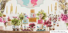 a table topped with lots of cakes and flowers