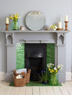 a fireplace with flowers and candles on the mantel above it is decorated in shades of green