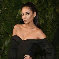 a woman in a black dress posing for the camera