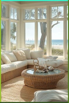 a living room filled with lots of furniture next to a large window overlooking the ocean