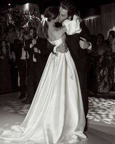 a bride and groom sharing a kiss on the dance floor at their wedding reception in black and white