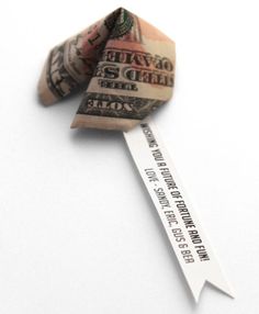 an origami dollar bill is tied to a ribbon with a message on it