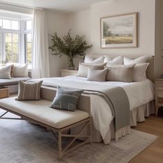 a large bed sitting next to a window in a bedroom