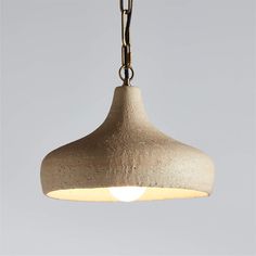 a wooden light hanging from a chain on a gray background with the light turned off