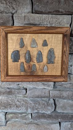 a wooden frame with rocks in it on a stone wall