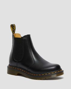 The Original DM's Chelsea boot. The 2976 dates back to the 70s and has a long-running heritage of music and mayhem. Here the classic silhouette returns in our classic Smooth leather, enhanced with yellow welt stitching and a scripted AirWair heel loop. The Chelsea boots sit on a robust air-cushioned sole, as they have since the start. The 2976 is the rugged Docs take on the classic Chelsea boot. Manufactured since the 70s Pull-on style, with elastic gussets Serves up all the signature Doc’s ... 2976 Chelsea Boots, Dr Martens 2976, Black Dr Martens, Yellow Heels, Chelsea Boots Women, Black Chelsea Boots, Leather Chelsea Boots, Goodyear Welt, Chelsea Boot