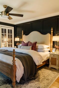 a bedroom with a bed, nightstands and ceiling fan