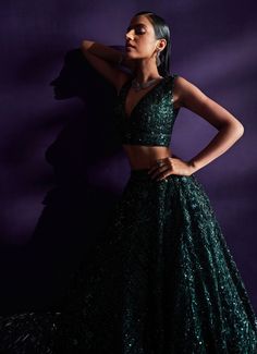 Introducing the exquisite Emerald Green Sequins Embroidered Lehenga Set, a masterpiece of elegance and sophistication. Crafted from delicate net fabric, this flowing green lehenga is meticulously adorned with tonal multi-cut sequins, crystals, and bugle beads, creating a mesmerizing shimmer that captivates with every movement. The intricate embroidery adds depth and richness, enhancing the luxurious appeal of the ensemble. Paired with a matching V-neckline blouse that perfectly balances the modern and traditional elements. Completed with an embellished dupatta for a cohesive, stunning look. Ideal for the bride or bride-to-be, especially for Cocktail or Sangeet nights, this lehenga set ensures you will be the center of attention, radiating timeless allure and unmatched opulence. Composition Green Semi-stitched Party Wear Gown, Party Green Anarkali Set With Intricate Embroidery, Green Anarkali Set With Intricate Embroidery For Party, Elegant Green Lehenga With Resham Embroidery, Party Wear Green Gown With Zari Work, Green Lehenga With Intricate Embroidery For Reception, Green Sharara With Intricate Embroidery For Party, Party Sharara In Green With Intricate Embroidery, Party Green Sharara With Intricate Embroidery