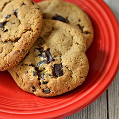 two chocolate chip cookies on a red plate